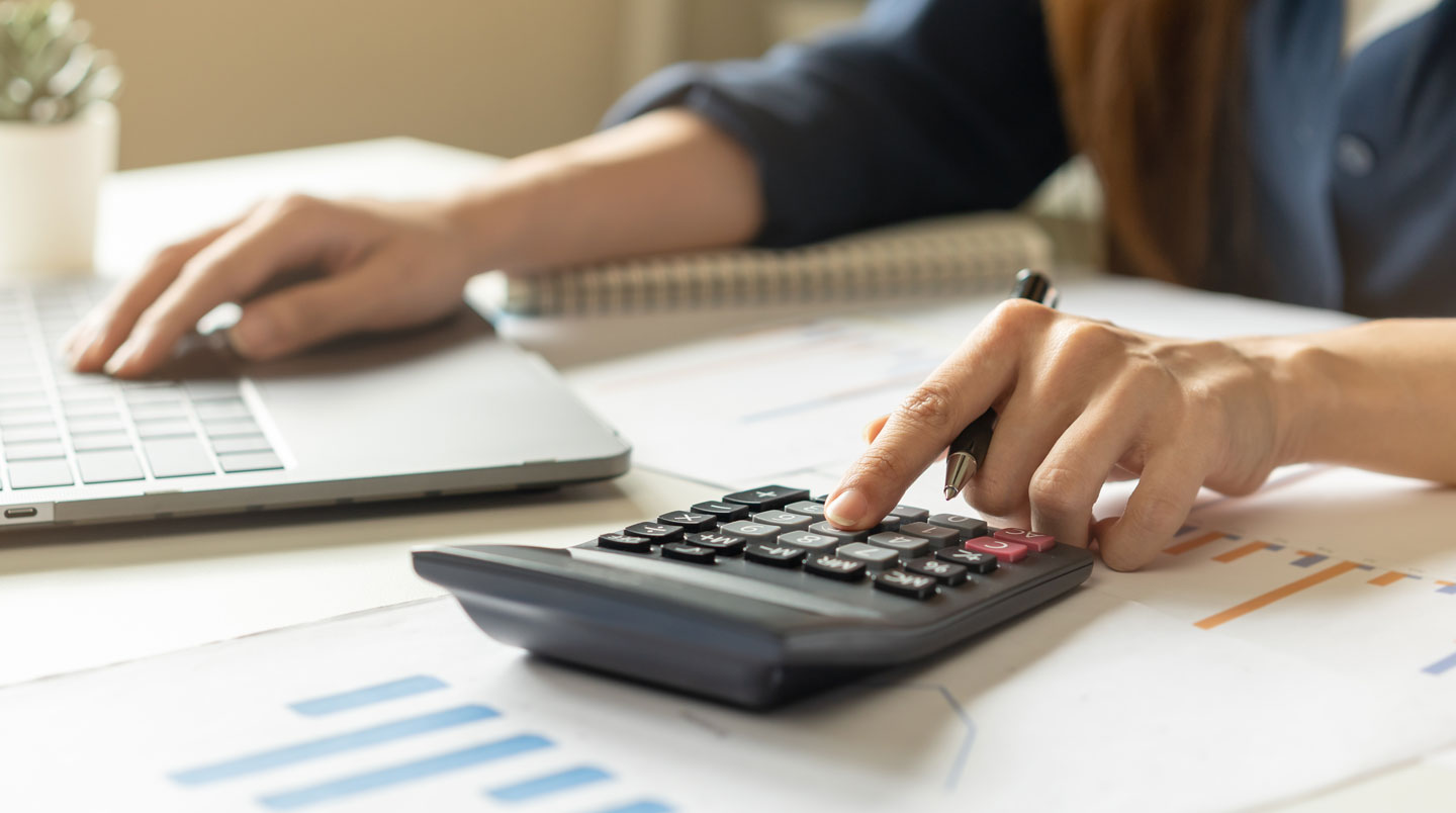 Directeur financier analysant documents budgétaires et tableur Excel avec colonnes comparatives de coûts développement interne versus externe sur bureau professionnel